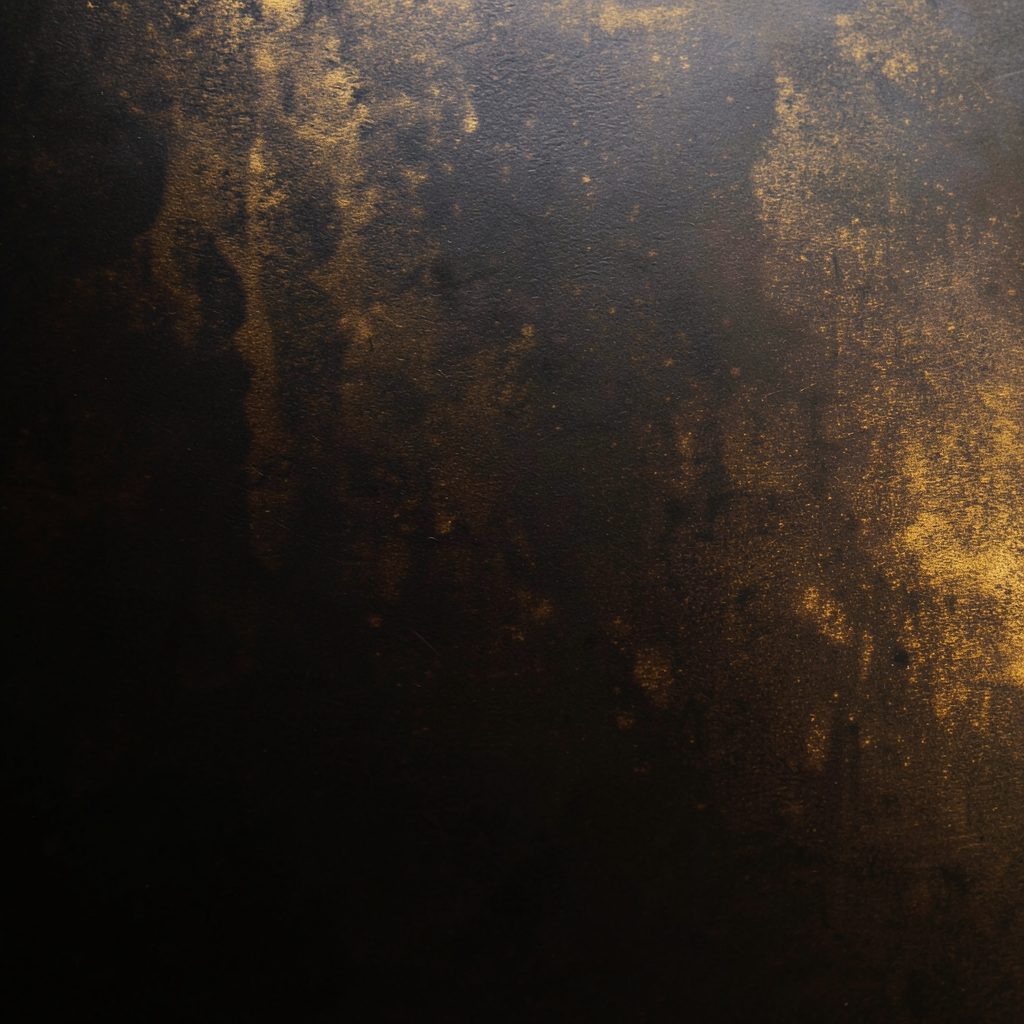 Close abstract texture of dark metallic surface with warm gold highlights, minimal and refined mood